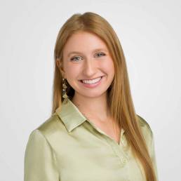 A corporate headshot of a woman wearing a light green blouse