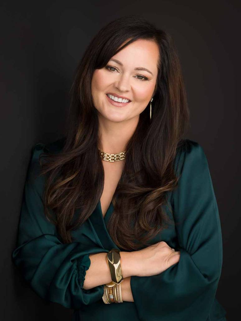 A woman CEO smiling at the camera for her headshot to be photographed