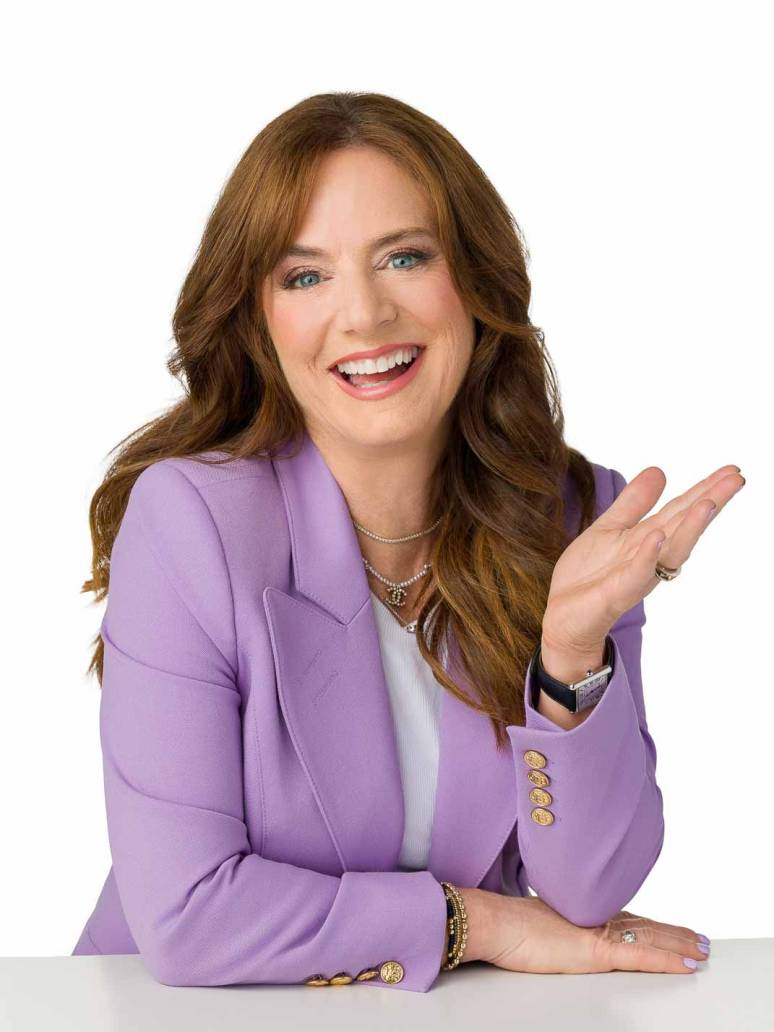 An executive portrait of a red haired woman wearing a lavender blazer with an excited and happy expression.