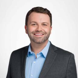 A company headshot of a Denver man smiling at the camera.