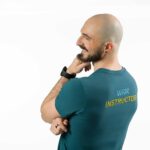 A WimHof instructor coach wearing a logo tshirt and looking to the side