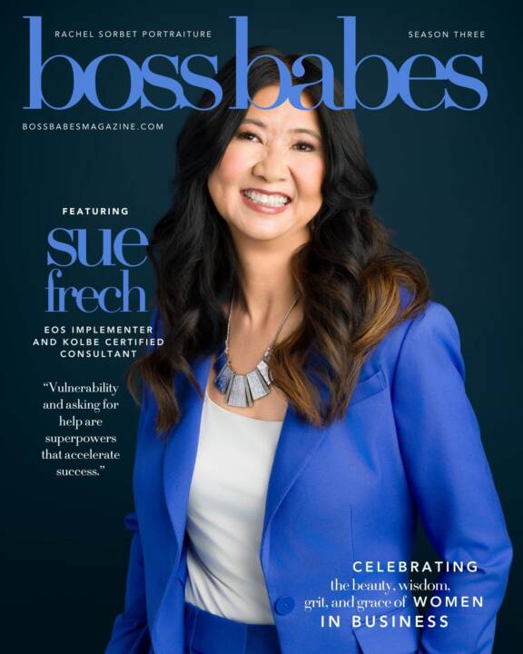 A beautiful long haired woman standing confidently in a blue suit on a navy background