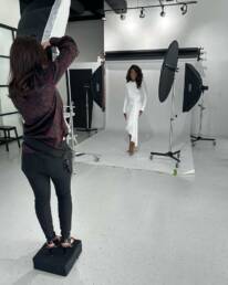 A behind the scenes look at a woman being photographed in studio