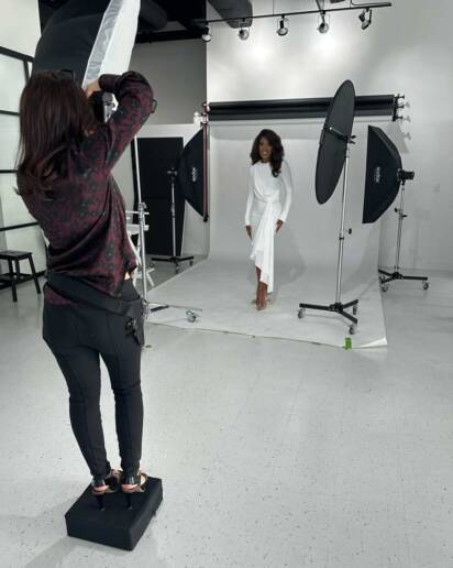 A behind the scenes look at a woman being photographed in studio