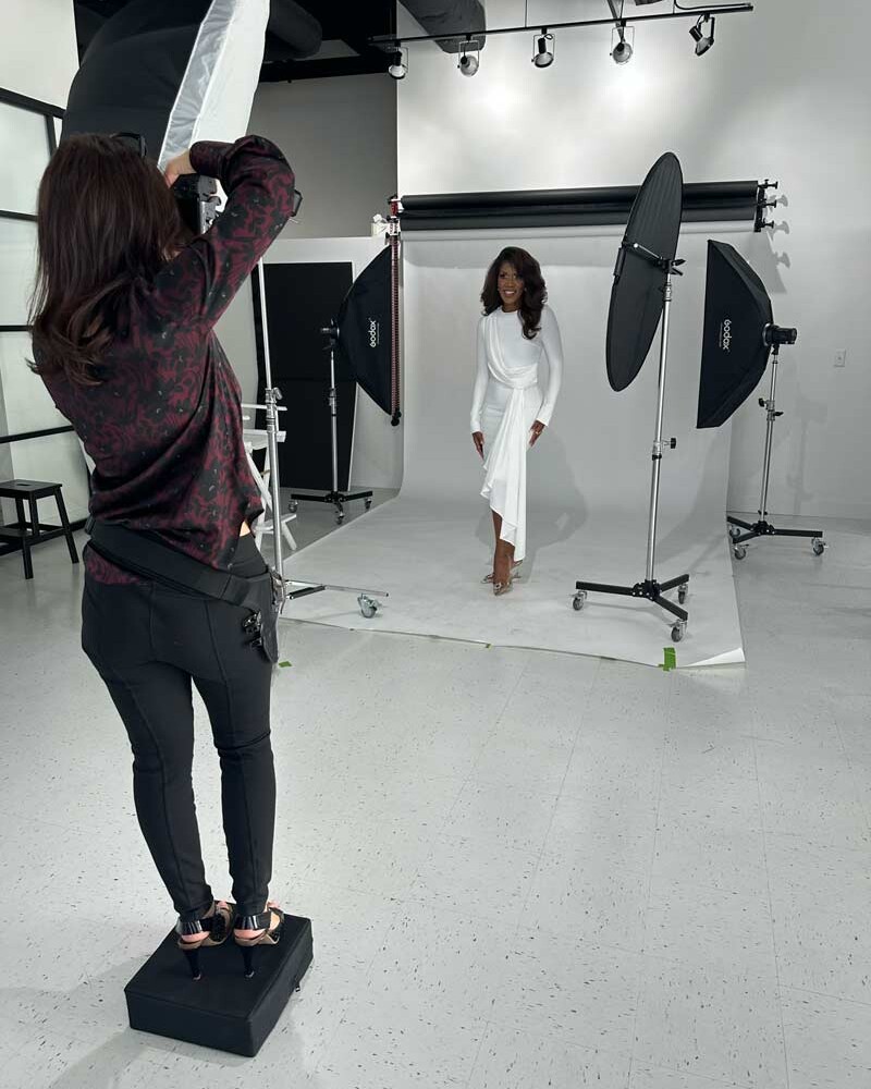 A behind the scenes look at a woman being photographed in studio