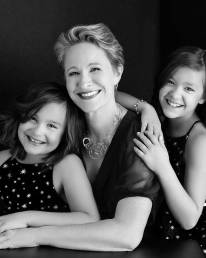 A mother snuggles with her twin daughters