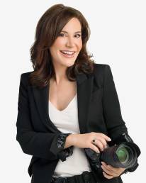 Denver Headshot Photographer Rachel Sorbet standing holding a camera